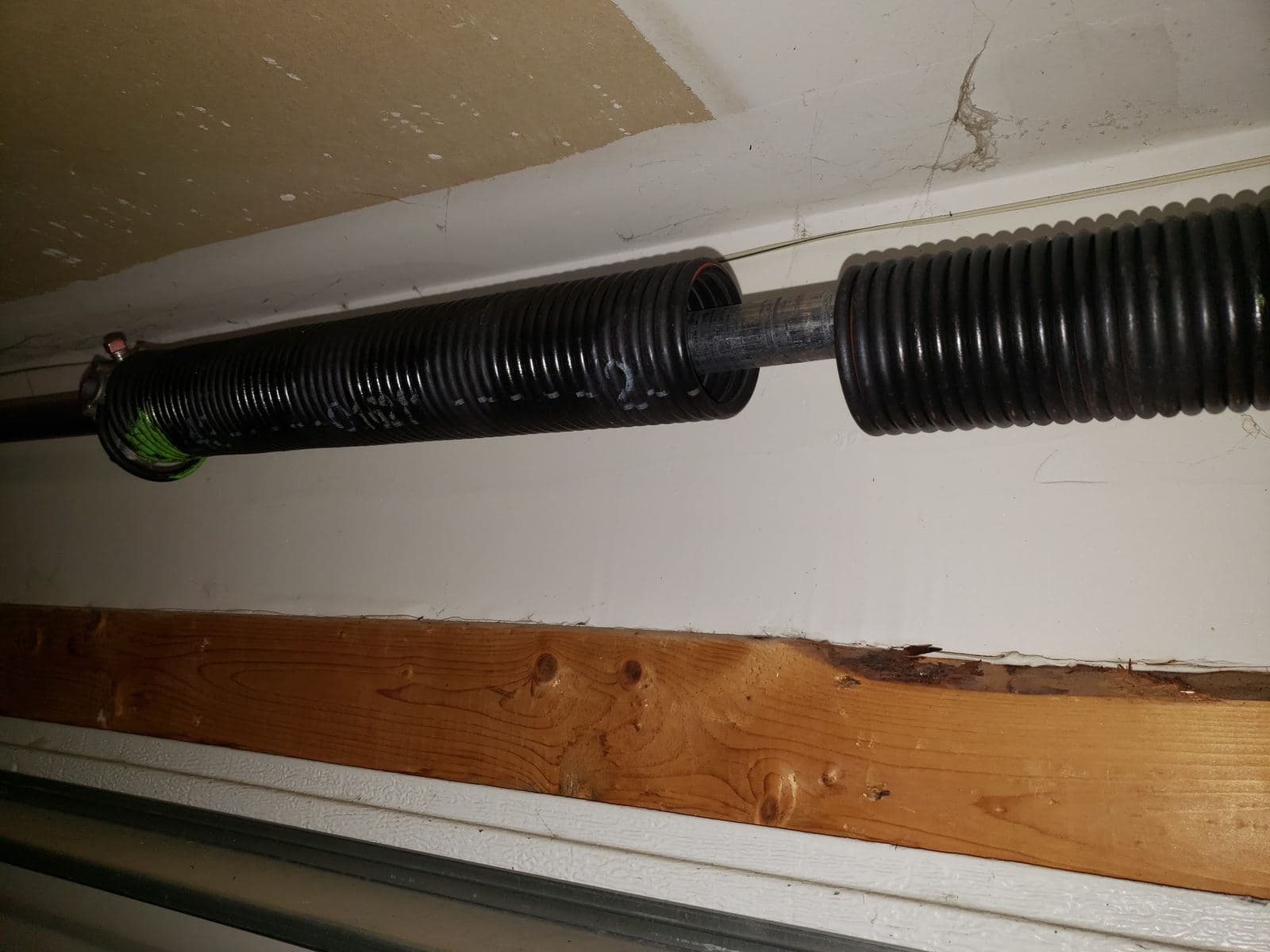 Two torsion springs mounted on the header above a garage door
