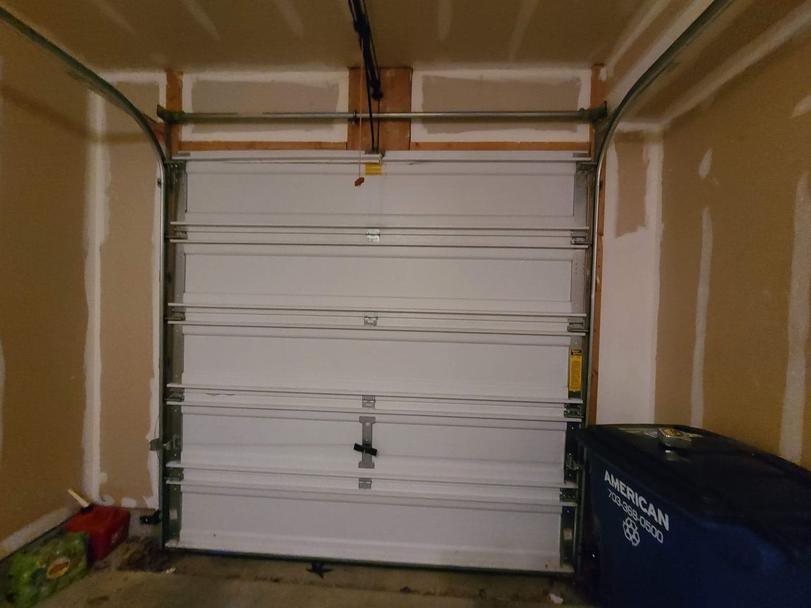 Inside view of a single garage door with its tracks, rollers and hinges